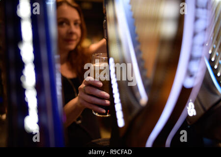 Donna che serve drink in un bar Foto Stock