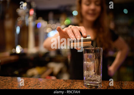 Donna che serve drink in un bar Foto Stock