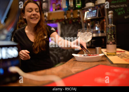 Donna che serve drink in un bar Foto Stock