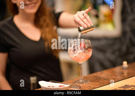 Donna che serve drink in un bar Foto Stock