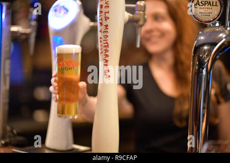 Donna che serve drink in un bar Foto Stock