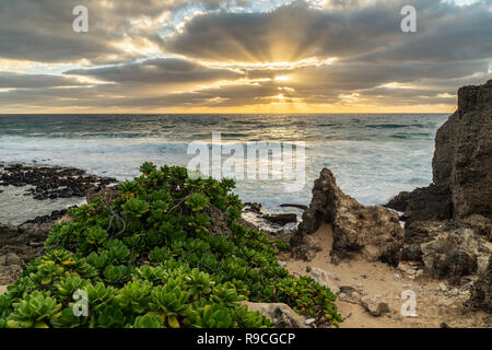 Raggi di Dio creato da nuvole che coprono il sole a Makawehi Bluff, Kauai, Hawaii Foto Stock