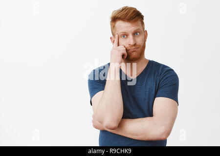 Uomo di perdere la mente udito argomentazioni. Addolorato eravamo stanchi e stufi bello redhead maschio maturo con setole, respirazione, tenendo il dito sul tempio e guardando verso il basso con infastidito e turbato l'espressione Foto Stock