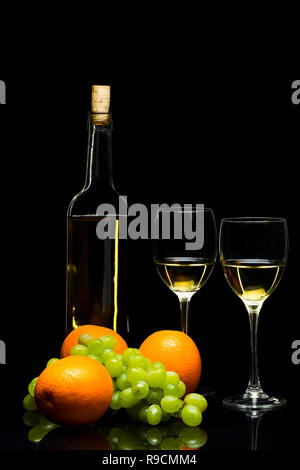 Tre Bicchieri per il vino, un grappolo di uva e arance su uno sfondo nero, studio luce Foto Stock