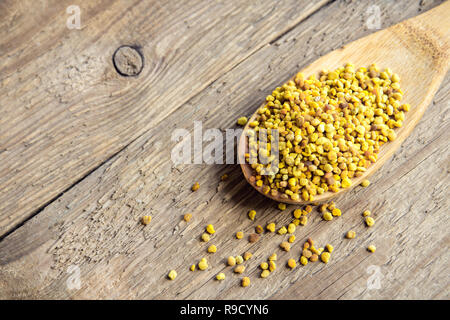 Polline di api in cucchiaio sullo sfondo di legno. Sana materie organiche la dieta vegetariana ingrediente alimentare, super - polline di api. Foto Stock