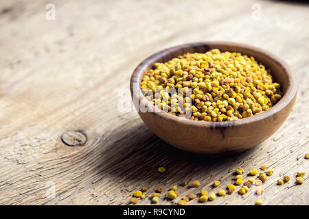 Polline di api in vaso su sfondo di legno. Sana materie organiche la dieta vegetariana ingrediente alimentare, super - polline di api. Foto Stock