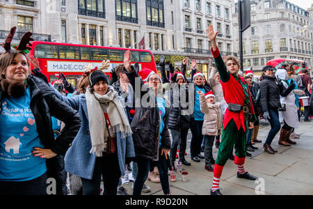 Hamleys' Elf Mike Rogers danze improvvisate con volontari da Londra i bambini ospizio Richard House, su Regent Street. Londra. Natale 2018 Foto Stock