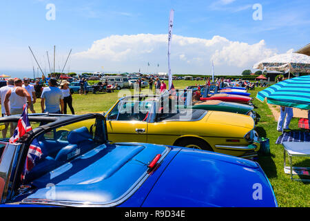 La benna e vanga classic car show sul lungomare di Ramsgate. Fila di sette vintage stadio trionfo delle vetture, in vari colori. Sole, cielo blu. Foto Stock