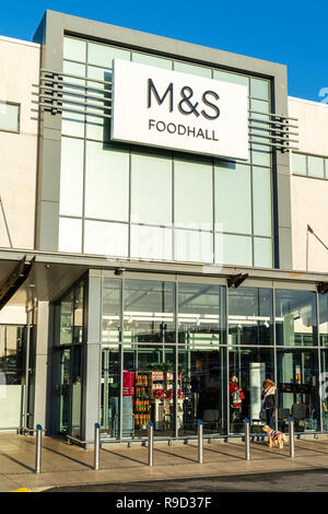 Westwood Cross Shopping Centre, Inghilterra. M&S store e food Hall ingresso inverno, la donna in attesa fuori con il proprio cane. Foto Stock