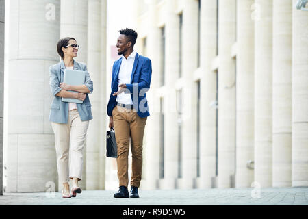 Happy office i colleghi a parlare quando si cammina Foto Stock