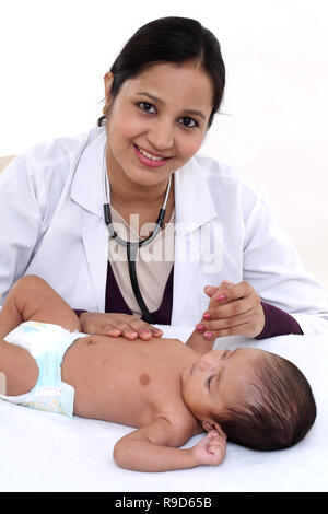 Allegro femmina trattiene pediatra neonato Foto Stock