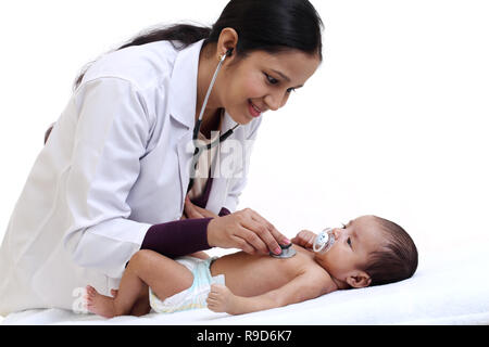 Allegro femmina trattiene pediatra neonato Foto Stock