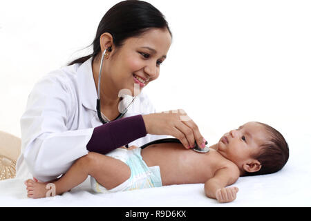 Allegro femmina trattiene pediatra neonato Foto Stock