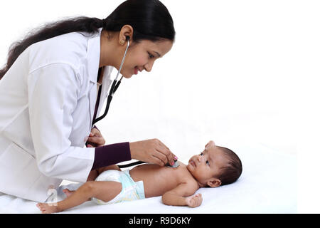 Allegro femmina trattiene pediatra neonato Foto Stock