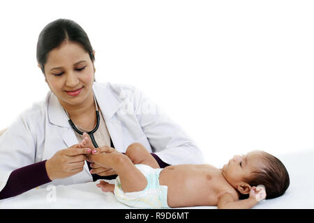 Allegro femmina trattiene pediatra neonato Foto Stock