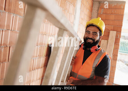 Ritratto di Felice lavoratore ispanica sorridente in sito in costruzione Foto Stock