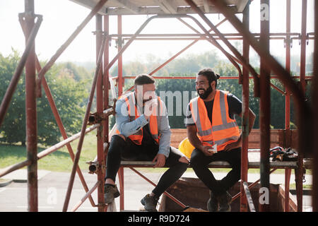 Felice di lavoratori in cantiere durante la pausa pranzo Foto Stock