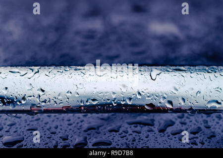 Auto ringhiera sul tetto abstract closeup dopo la pioggia, stato d'animo scuro, red reflection Foto Stock