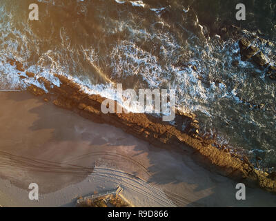 Grande roccia sulla spiaggia antenna fuco sopra visualizza nella soleggiata luce tempo Foto Stock