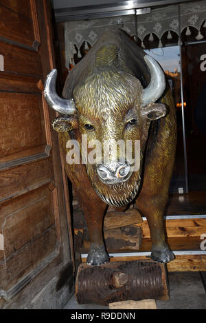 In Cracovia Polonia attrazioni includono la piazza principale del Mercato di Santa Maria la Basilica e il panno Sukiennice.Bronzo statua Bisonte al di fuori di un ristorante Foto Stock