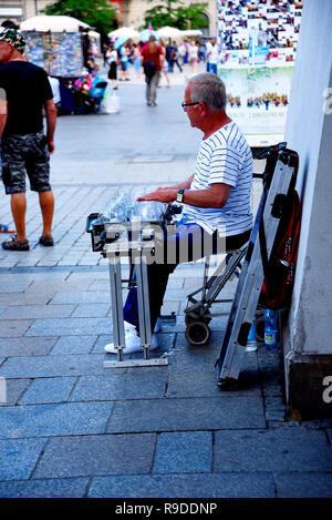 Cracovia in Polonia è un' antica città fortificata visitato da migliaia di turisti. Buskers velo la loro arte nelle piazze e spazi aperti per deliziare i turisti Foto Stock