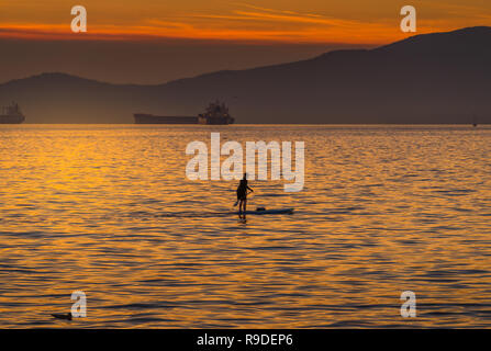 Donna su paddleboard di English Bay, Vancouner al tramonto Foto Stock