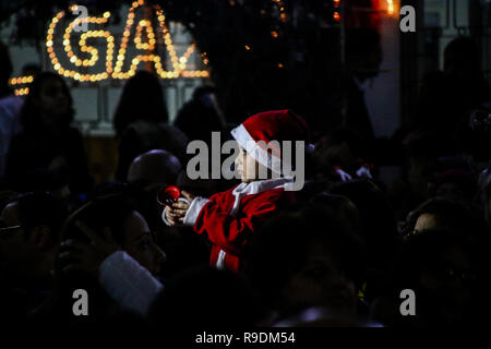 La città di Gaza, Palestina. 22 dic 2018. Il YMCA nella Striscia di Gaza organizzare la cerimonia di illuminazione dell'albero di Natale in piazza a Gaza City la sera del 22 dicembre 2018. Un palestinese danze folkloristiche e la benedizione di un patriarca greco-ortodosso accompagnato la cerimonia nella corsa fino alla vigilia di Natale. Entrambi i Palestinesi cristiani e musulmani fatta convergere nella piazza di Gaza a celebrare e a godere le decorazioni e le altre tradizioni di stagione, come ad esempio i bambini della foto con Babbo Natale e le collezioni di carità per i più bisognosi. Credito: ZUMA Press, Inc./Alamy Live News Foto Stock