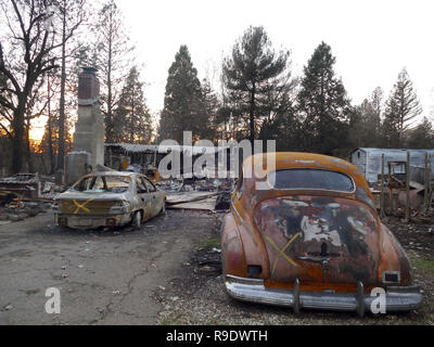 Paradise, STATI UNITI D'AMERICA. Xix Dec, 2018. Un bruciato auto si trova di fronte ad una rovina in bruciato Down Town Center. Il devastante "camp' incendio in Paradiso ha quasi completamente distrutto la città nel nord della California. Sei settimane dopo la fiamma inferno, lo stato di emergenza ancora prevale. (A dpa " Croci, ceneri e speranza - Paradiso non rinunciare dopo Feuerinferno' del 23.12.2018) Credito: Barbara Munker/dpa/Alamy Live News Foto Stock