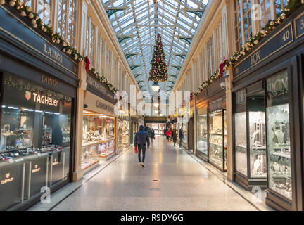 Glasgow, Scozia, Regno Unito. 23 dicembre 2018. Gli acquirenti di Natale nella Argyll Arcade, che contiene una vasta selezione di negozi di gioielli. La Arcade è stata progettata da John Baird e costruita nel 1827, è a forma di L e collega Argyle Street con Buchanan Street. La galleria fu classificata di grado A nel 1970. Credito: SKULLY/Alamy Live News Foto Stock