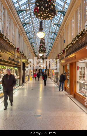 Glasgow, Scozia, Regno Unito. 23 dicembre 2018. Gli acquirenti di Natale nella Argyll Arcade, che contiene una vasta selezione di negozi di gioielli. La Arcade è stata progettata da John Baird e costruita nel 1827, è a forma di L e collega Argyle Street con Buchanan Street. La galleria fu classificata di grado A nel 1970. Credito: SKULLY/Alamy Live News Foto Stock