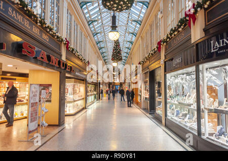 Glasgow, Scozia, Regno Unito. 23 dicembre 2018. Gli acquirenti di Natale nella Argyll Arcade, che contiene una vasta selezione di negozi di gioielli. La Arcade è stata progettata da John Baird e costruita nel 1827, è a forma di L e collega Argyle Street con Buchanan Street. La galleria fu classificata di grado A nel 1970. Credito: SKULLY/Alamy Live News Foto Stock