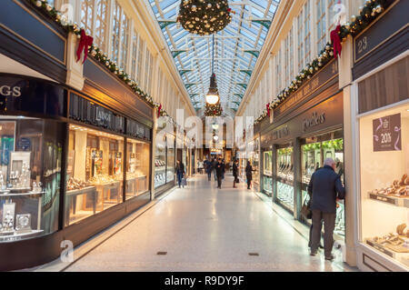 Glasgow, Scozia, Regno Unito. 23 dicembre 2018. Gli acquirenti di Natale nella Argyll Arcade, che contiene una vasta selezione di negozi di gioielli. La Arcade è stata progettata da John Baird e costruita nel 1827, è a forma di L e collega Argyle Street con Buchanan Street. La galleria fu classificata di grado A nel 1970. Credito: SKULLY/Alamy Live News Foto Stock