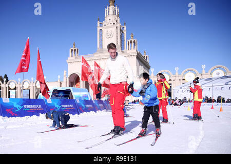 Pechino, Cina. 23 Dic, 2018. Un atleta dalla Norvegia insegna ai bambini a sciare durante un ghiaccio e neve fair di Pechino, capitale della Cina, Dic 23, 2018. Credito: Chen Xiaogen/Xinhua/Alamy Live News Foto Stock