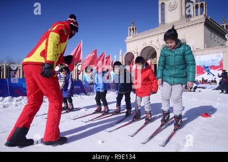 Pechino, Cina. 23 Dic, 2018. I bambini vengono guidati a sciare durante un ghiaccio e neve fair di Pechino, capitale della Cina, Dic 23, 2018. Credito: Chen Xiaogen/Xinhua/Alamy Live News Foto Stock