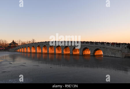 Pechino, Cina. 23 Dic, 2018. Il Qikong ponte con la luminosità del tramonto che brilla attraverso i suoi fori è visto presso il Palazzo Estivo di Pechino, capitale della Cina, Dec, 23, 2018. Credito: Chen Yehua/Xinhua/Alamy Live News Foto Stock