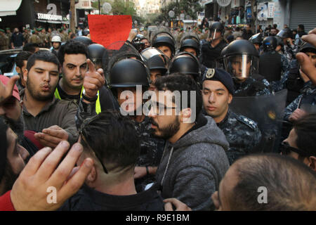 Beirut, Libano. 23 Dic, 2018. Persone scaramuccia con poliziotti durante una manifestazione di protesta contro i mesi-lungo fallimento del rivale fazioni politiche per accordarsi sulla formazione di un nuovo governo che potrebbe affrontare il paese della crisi. Credito: Marwan Naamani/dpa/Alamy Live News Foto Stock