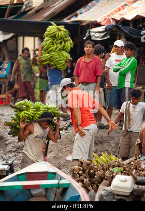 Persone che trasportano le banane e altri prodotti di base a Belen in Perù Foto Stock