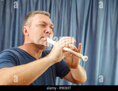 Uomo eldrly riproduzione di flauto in concert hall closeup Foto Stock