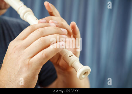 Uomo eldrly riproduzione di flauto in concert hall. mani closeup Foto Stock