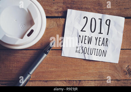 Risoluzione per 2019 parola su carta con la penna e la tazza di caffè sul tavolo di legno. Il concetto di business. Foto Stock