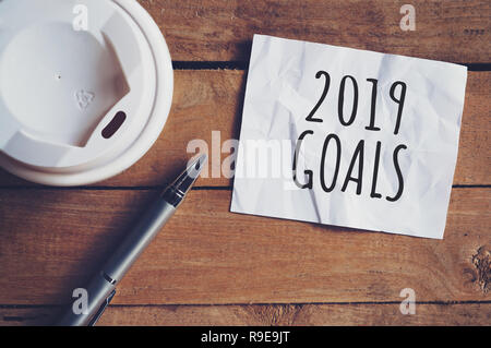 Gli obiettivi per il 2019 la parola su un foglio di carta con la penna e la tazza di caffè sul tavolo di legno. Il concetto di business. Foto Stock