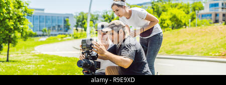 Un cameraman operatore discutere il processo di ripresa con un direttore e dp banner, formato lungo Foto Stock