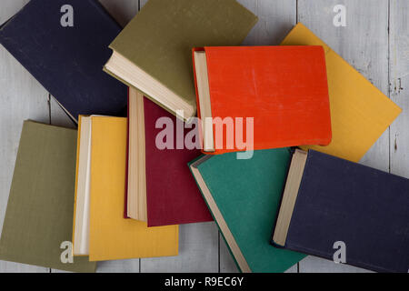 Si torna a scuola e istruzione concetto - vista superiore di heap hardback colorati libri su bianco tavolo in legno Foto Stock