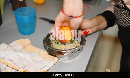 Donna spremendo il limone sul bancone, succo di agrumi ingrediente in cucina, unstaged, nessuno, close up delle mani con unghie curati, casalinga concept Foto Stock