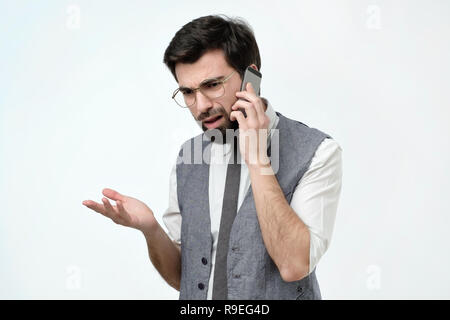 Arrabbiato uomo spagnolo parlando al telefono Foto Stock