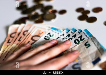 Close up di banconote in euro e centesimi di euro e monete su uno sfondo bianco. Il denaro, la concezione di business. Foto Stock