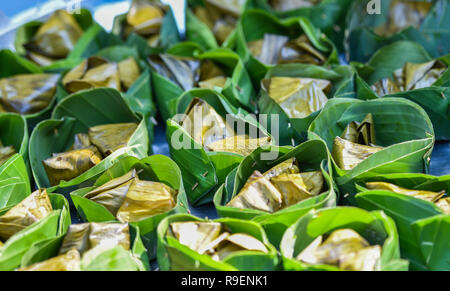 I dessert Thai sulla banana leaf cuocere / tradizionale dei cibi e dolci cotti al vapore riso appiccicoso con banana e fagiolo wrap con banana leaf background Foto Stock