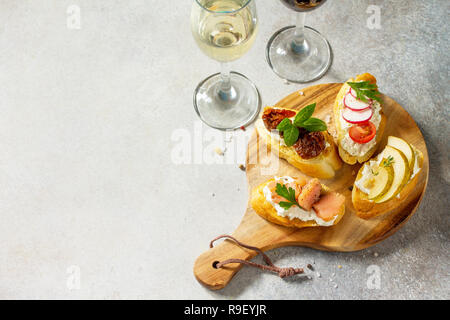 Antipasti italiani spuntini impostato per il vino. Spaghetti con formaggio a pasta morbida, pera, Rafano, salmone e pomodori secchi su una pietra di luce sullo sfondo. Copia dello spazio. Foto Stock