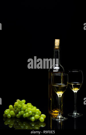 Tre Bicchieri per il vino, un grappolo di uva e arance su uno sfondo nero, studio luce Foto Stock