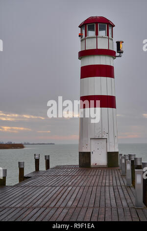 Il faro di Podersdorf alla fine di un molo di legno a Neusiedler SEE al tramonto, un punto di riferimento iconico nel Burgenland, Austria Foto Stock